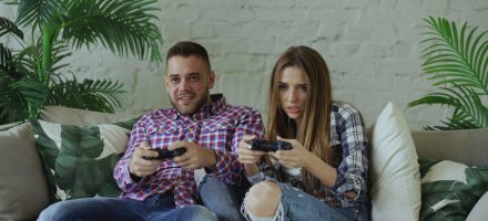 Young millennial guy and woman gaming together